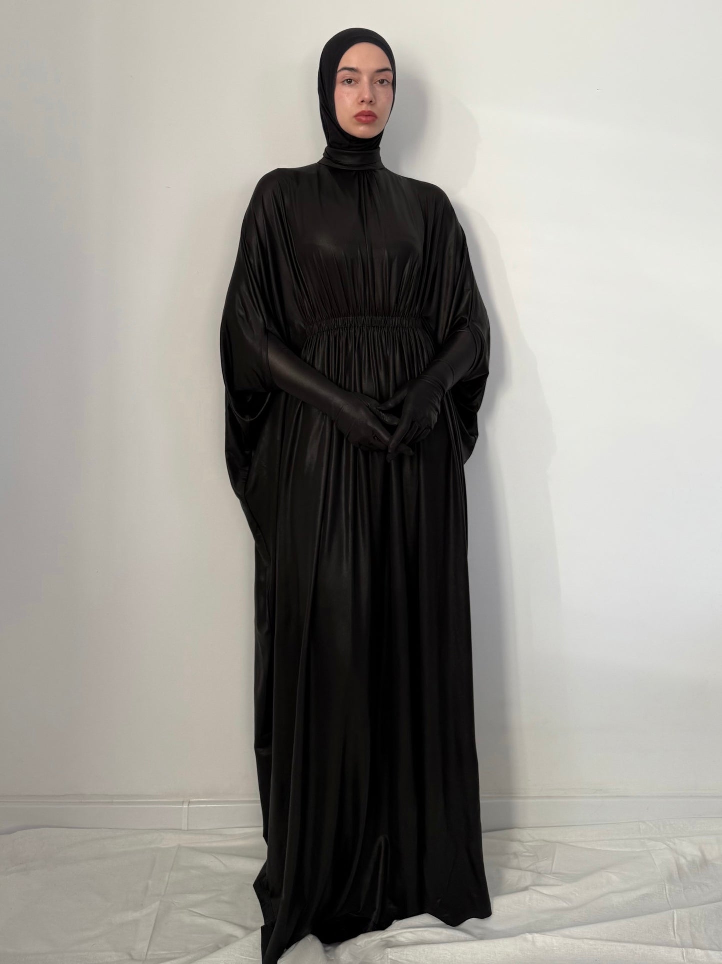 Person wearing a black abaya against a white background