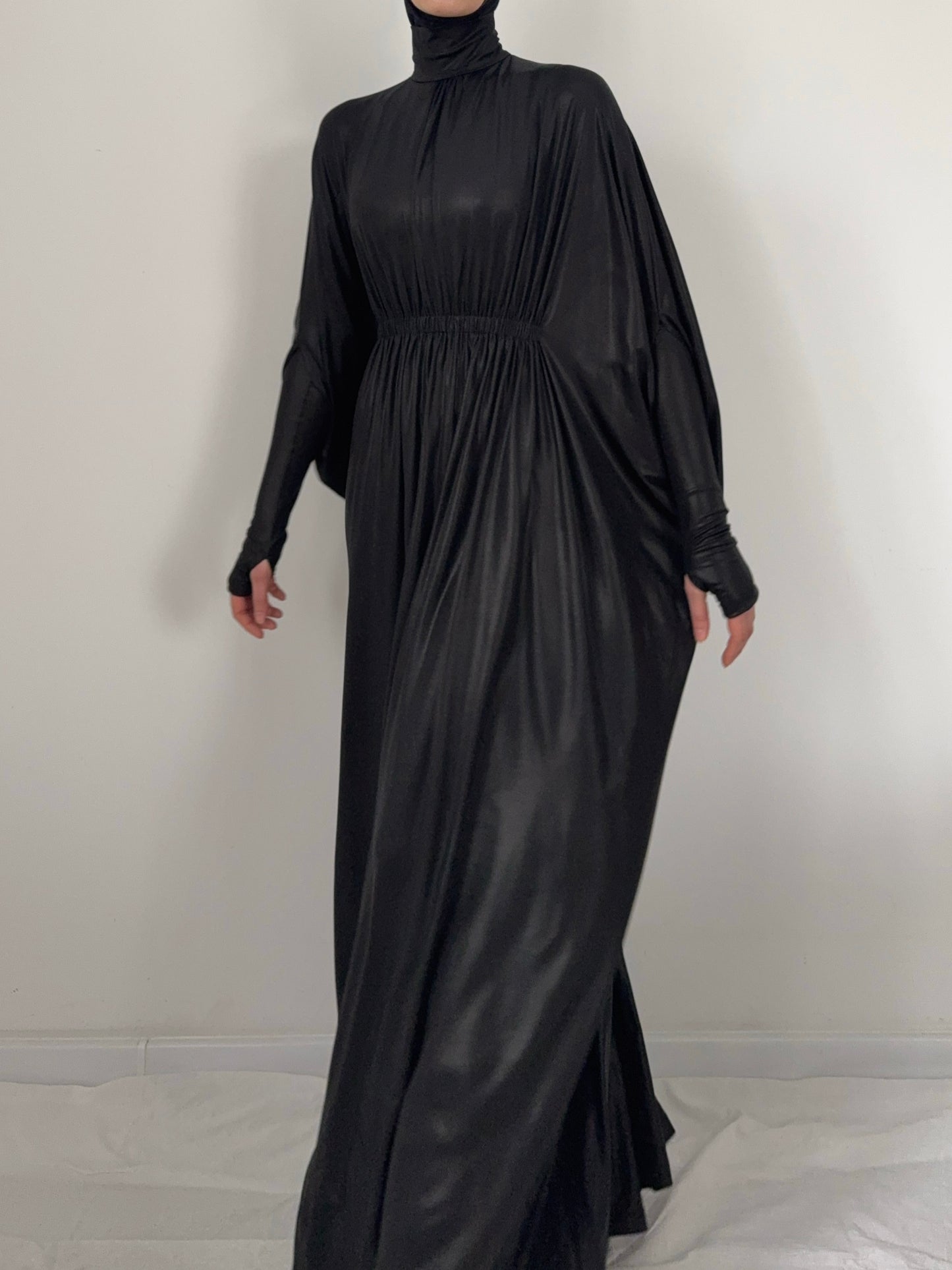 Black long-sleeve dress on a mannequin against a plain background